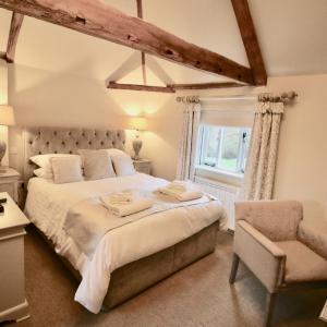 um quarto com uma cama grande e uma cadeira em Kings Head Bawburgh em Norwich
