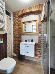 a bathroom with a white sink and a brick wall at Strażacka 2 in Karpacz