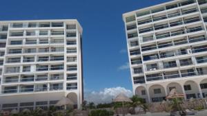 due alti edifici bianchi uno accanto all'altro di Ocean View Room 1202near The Clubs a Cancún