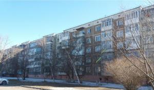 a large brick building with trees in front of it at 1-комнатная квартира in Kokshetau