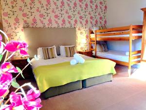 a bedroom with two bunk beds and pink flowers at Kirkhill Estate Rooms in Gorebridge