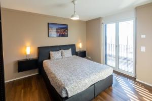- une chambre avec un lit, deux lampes et une fenêtre dans l'établissement SKYLINE Exclusive Penthouse Apartments, à Bâle
