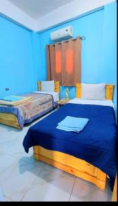 a bedroom with two beds with blue walls at Dahab in Dahab