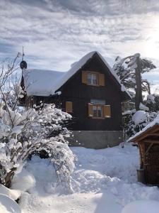 ein schneebedecktes Haus vor der Tür in der Unterkunft Chata Prístav in Námestovo
