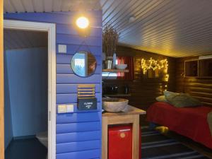 ein Zimmer mit einer blauen Wand und einem Bett in der Unterkunft Saarituvat Cottages in Rovaniemi