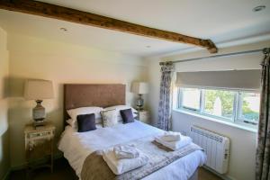 a bedroom with a bed with white sheets and a window at Kings Head Bawburgh in Norwich