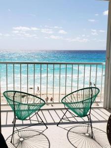 two chairs on a balcony looking at the beach at Studio 101 in the heart of the Hotel Zone in Cancún