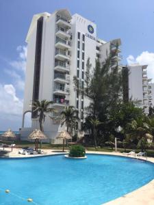 a swimming pool in front of a hotel at Studio 101 in the heart of the Hotel Zone in Cancún