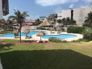 a view of a pool with umbrellas and a resort at Studio 101 in the heart of the Hotel Zone in Cancún