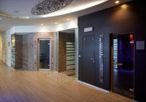 Habitación con un pasillo con puertas negras y suelo de madera. en Blu Hotel Acquaseria, en Ponte di Legno