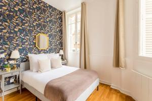 a bedroom with a bed with a floral wallpaper at Cosy 3 Bedroom 1 bathroom - Champs Elysees in Paris