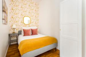 een slaapkamer met een bed met een gele deken bij Cosy 3 Bedroom 1 bathroom - Champs Elysees in Parijs
