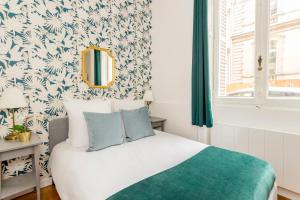 a bedroom with a bed with a green and white wallpaper at Cosy 3 Bedroom 1 bathroom - Champs Elysees in Paris