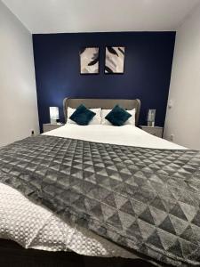 a bedroom with a large bed with blue walls at Stylish 2bed house in birmingham in Birmingham