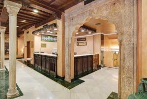 a lobby with columns and a bar in a building at Sercotel Palacio de los Gamboa in Granada