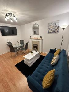 a living room with a blue couch and a table at Stylish 2bed house in birmingham in Birmingham