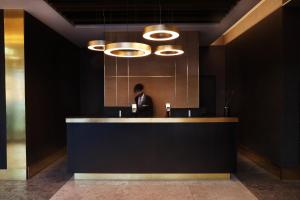 a man in a suit sitting at a reception desk at Hótel Reykjavík Saga in Reykjavík