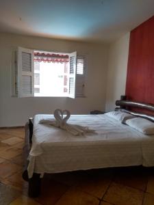 a bedroom with a bed with a ribbon on it at Casa Cohiba in Cumbuco