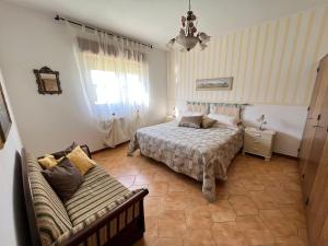 ein Schlafzimmer mit einem Bett und einem Sofa in der Unterkunft Casa vacanze La Via del Mare in Scanzano