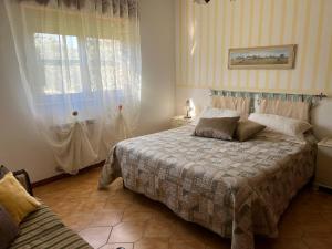 Schlafzimmer mit einem Bett und einem Fenster in der Unterkunft Casa vacanze La Via del Mare in Scanzano