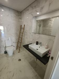 uma casa de banho com um lavatório, um espelho e um WC. em CasaMaeDouro em Peso da Régua