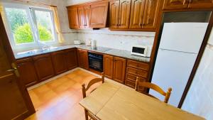eine Küche mit Holzschränken und einem weißen Kühlschrank in der Unterkunft Villa Neus in Sant Climent