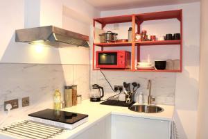 a small kitchen with a sink and a microwave at Modern studio apartment; 10min walk to town & quay in Exeter