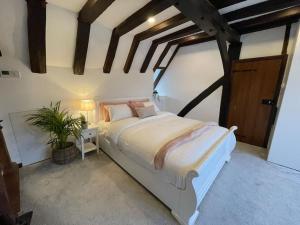 Un dormitorio con una cama grande en una habitación con techos de madera. en Rural Country Suites - Judge's Lodge, en East Grinstead