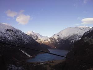a view of a snowy mountain range with a lake at Lunheim in Geiranger in Geiranger