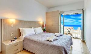 een slaapkamer met een bed en uitzicht op de oceaan bij Fodele Beachfront Apts, Βy IdealStay Experience in Fodele