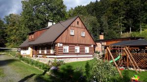 ein großes Holzhaus mitten im Hof in der Unterkunft Chalupa Čistá v Krkonoších 8 in Černý Důl