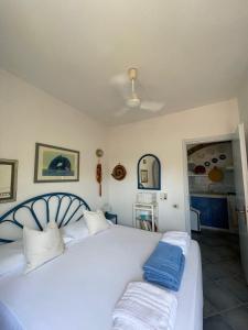 um quarto com uma cama branca e 2 almofadas azuis em Domus Deborah Apartment with sea view Costa rei em Costa Rei
