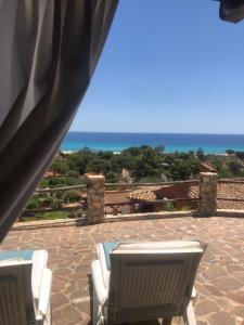 um pátio com cadeiras e vista para o oceano em Domus Deborah Apartment with sea view Costa rei em Costa Rei