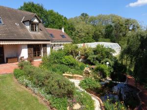 un jardín con un estanque frente a una casa en Chambres d'hôtes Legros, en Vierzon