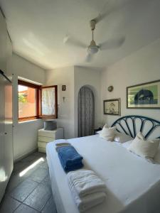 um quarto com uma grande cama branca com toalhas em Domus Deborah Apartment with sea view Costa rei em Costa Rei