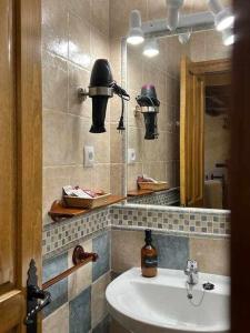 y baño con lavabo y espejo. en El Sobrao de Gredos en Navarredonda de Gredos