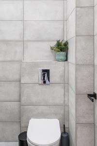 baño con aseo y planta en la pared en London Paddington Station Apartments, en Londres