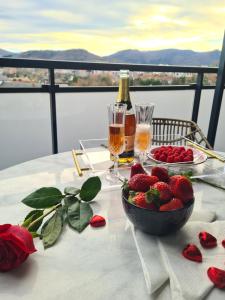 una mesa con un tazón de fresas y una botella de champán en Apartamento Nicores Bidasoa en Irún