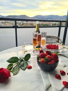 una mesa con un tazón de fresas y una botella de champán en Apartamento Nicores Bidasoa, en Irún