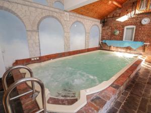 uma piscina interior num edifício com uma parede de tijolos em The Byre em Worcester