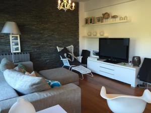 a living room with a couch and a tv at Apartamento Bahía de Plentzia in Plentzia