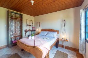 a bedroom with a large wooden bed in a room at Apartamentos exclusivos e equipado com varanda ou terraço com Pôr do sol, cozinha privativa, Wi-Fi 600MBs, a 700m da praia de Itapirubá e 1km da BR-101 in Imbituba +193 photos
