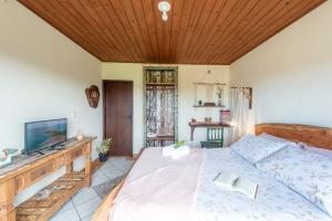 - une chambre avec un grand lit et un plafond en bois dans l'établissement Praia Itápiruba 600m - WI-FI 800Mg - 1,5km BR 101 - Espaço comp - Varanda c Pôr do sol, à Imbituba