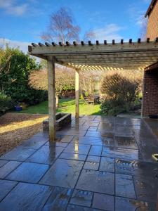a patio with a wooden pergola and a table at Field View B&B in Eastrington