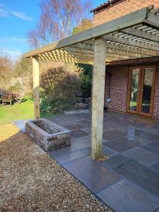 a patio with a wooden pergola and a brick building at Field View B&B in Eastrington