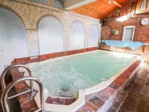 uma piscina interior num edifício com uma parede de tijolos em The Orangery em Worcester