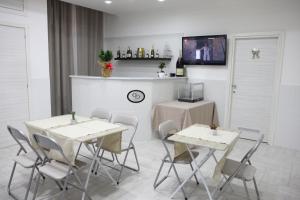 uma sala de jantar com duas mesas e cadeiras e uma televisão em Albergo Casablanca em Nápoles