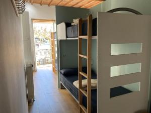 a room with bunk beds and a door with a window at Albergue O Santo in Arzúa