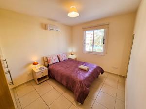 een slaapkamer met een bed en een raam bij Yaar Apartment with pool, tennis court and Bathroom with Bathtub in Pyla