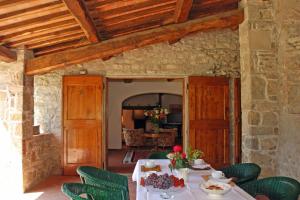 a dining room with a table and green chairs at Pozza di Volpaia by Salogi Villas in Radda in Chianti
